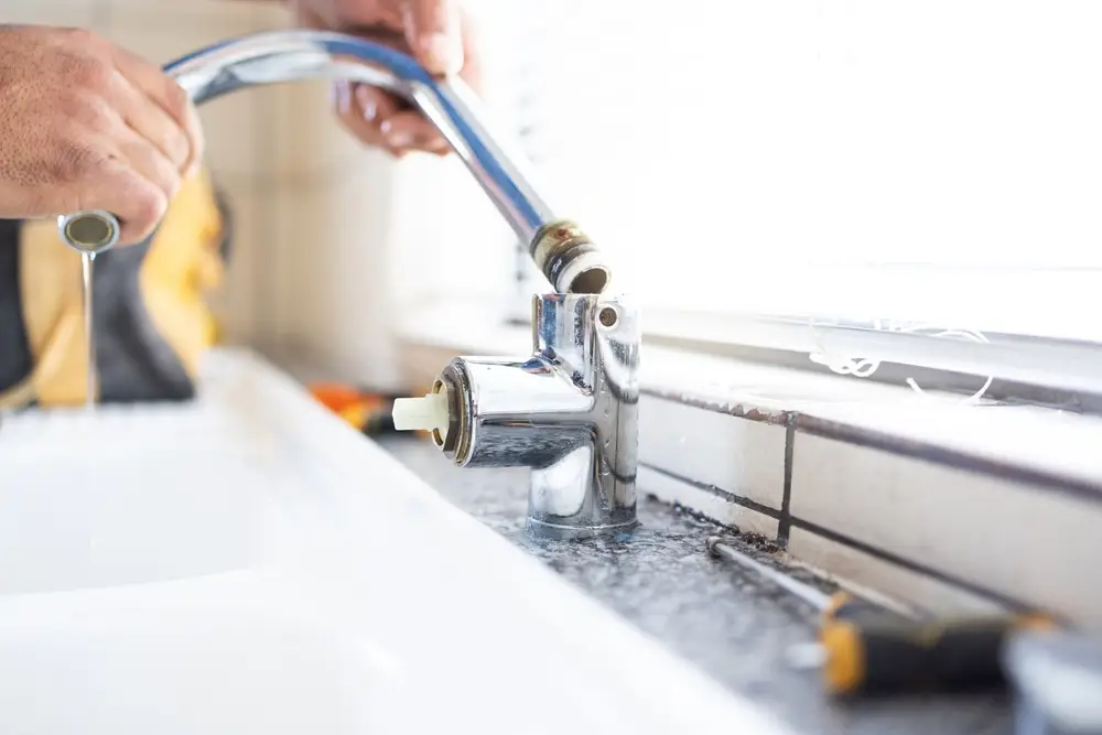 Plumber performing faucet maintenance